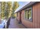 Inviting cabin with a spacious wooden deck and snow-covered roof, surrounded by lush pine trees at 324 County Road 672, Breckenridge, CO 80424
