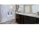 Bathroom featuring double vanity with dark cabinets and a glass enclosed shower at 6905 Fraser Cir, Frederick, CO 80530