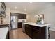 Contemporary kitchen featuring stainless steel appliances, dark wood cabinets, and bright white countertops at 6905 Fraser Cir, Frederick, CO 80530