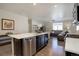 Modern kitchen features stainless steel appliances, a large island, and sleek black cabinets at 6905 Fraser Cir, Frederick, CO 80530