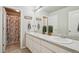 Well-lit bathroom featuring double sinks with granite counters and a shower with curtain at 6520 Empire Ave, Frederick, CO 80516
