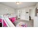 Bright bedroom with a bunk bed with slide, decorated with colorful rugs and toys at 6520 Empire Ave, Frederick, CO 80516