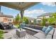 Enjoy the outdoors from this covered patio with cozy seating, overlooking the beautifully landscaped yard at 6520 Empire Ave, Frederick, CO 80516