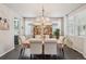 Bright dining room with large windows, elegant chandelier, and a dining table with six chairs at 6520 Empire Ave, Frederick, CO 80516