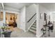 Spacious hallway with staircase leading to the upper level, and an open room with furniture at 6520 Empire Ave, Frederick, CO 80516