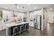 Modern kitchen with white cabinets, stainless steel appliances, island with seating, and hardwood floors at 6520 Empire Ave, Frederick, CO 80516