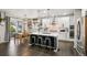 Spacious kitchen with an island, modern appliances, dark hardwood flooring, and access to a dining area at 6520 Empire Ave, Frederick, CO 80516
