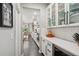 Hallway view of the kitchen with white cabinets, quartz countertops, subway tile backsplash, and stainless steel appliances at 6520 Empire Ave, Frederick, CO 80516
