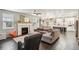 Open-concept living room with a fireplace, hardwood floors, and seamless access to the kitchen and dining area at 6520 Empire Ave, Frederick, CO 80516