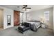Bedroom featuring neutral walls, carpet, windows, a barn door and a black chaise lounge at 6520 Empire Ave, Frederick, CO 80516