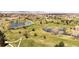 A scenic aerial view of the golf course features ponds and winding paths at 8210 W 72Nd Pl, Arvada, CO 80005