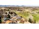 Aerial neighborhood view featuring a lush golf course, lake, nearby houses and beautiful mountain views at 8210 W 72Nd Pl, Arvada, CO 80005