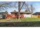 Well-kept backyard featuring green grass, a charming deck area, and mature trees at 8210 W 72Nd Pl, Arvada, CO 80005