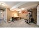 Multi-purpose basement room with an exercise area, desk space, and adjacent bathroom at 8210 W 72Nd Pl, Arvada, CO 80005