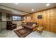 Cozy basement featuring wood paneling, neutral carpet, and comfortable seating area perfect for relaxing at 8210 W 72Nd Pl, Arvada, CO 80005