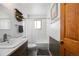 Bright bathroom features a sink, toilet, shower, and storage shelves at 8210 W 72Nd Pl, Arvada, CO 80005