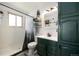 Bathroom with a shower, a vanity with a forest green cabinet, and decorative nature themed decor at 8210 W 72Nd Pl, Arvada, CO 80005