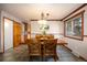 Bright dining room featuring a large window and an open view to the kitchen at 8210 W 72Nd Pl, Arvada, CO 80005