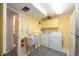 Bright laundry room features a utility sink, washer, dryer, and ample cabinet space for storage at 8210 W 72Nd Pl, Arvada, CO 80005
