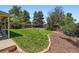 Landscaped backyard with mature trees and mulch beds at 10247 W Arkansas Ave, Lakewood, CO 80232
