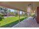 Covered patio with brick flooring and view of the landscaped backyard at 10247 W Arkansas Ave, Lakewood, CO 80232