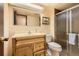Bathroom with wood vanity, frosted glass shower, toilet and decorative mirror at 10247 W Arkansas Ave, Lakewood, CO 80232