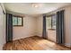 Bedroom featuring hardwood floors and bright windows with modern curtains and natural light at 10247 W Arkansas Ave, Lakewood, CO 80232