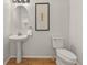 Powder bath featuring a pedestal sink, hardwood flooring, and stylish decor at 15612 E 96Th Way # 9B, Commerce City, CO 80022