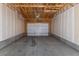An empty two car garage, highlighting the exposed wood ceiling structure and concrete floor at 15612 E 96Th Way # 9B, Commerce City, CO 80022