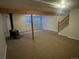 Spacious basement featuring a wood-burning stove, exposed beams, and egress windows for natural light at 2617 S Cimarron St, Aurora, CO 80014