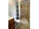 Updated bathroom with new shower, updated vanity, tile floor, and convenient shelving at 2617 S Cimarron St, Aurora, CO 80014