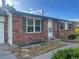 Close up of brick home with green shutters and a white front door at 2617 S Cimarron St, Aurora, CO 80014