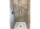 Tile shower with shower head and neutral tile at 2617 S Cimarron St, Aurora, CO 80014