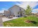 Spacious backyard with a concrete patio, lawn, and exterior of the home at 7415 E 158Th Pl, Thornton, CO 80602