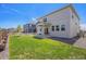 Large grassy backyard with a view of the home's exterior and neighboring houses at 7415 E 158Th Pl, Thornton, CO 80602