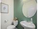 Half-bathroom with a decorative vanity, a round mirror, stylish wall paint, and modern fixtures at 7415 E 158Th Pl, Thornton, CO 80602