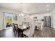 Open dining and kitchen area with modern appliances, white cabinets, an island, and wooden dining table at 7415 E 158Th Pl, Thornton, CO 80602
