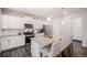 Modern kitchen boasts white cabinets, stainless steel appliances, a large island, and bar stool seating at 7415 E 158Th Pl, Thornton, CO 80602