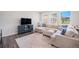 Comfortable living room with a large sectional sofa, a blue media center, and bright windows at 7415 E 158Th Pl, Thornton, CO 80602
