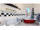 Charming bathroom features red clawfoot tub, black and white tile, and classic fixtures at 2227 N Ogden St, Denver, CO 80205