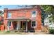 Charming brick two-story home featuring a covered porch, two front doors, and a well-maintained lawn at 2227 N Ogden St, Denver, CO 80205