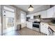 Charming kitchen features white cabinets, stainless steel appliances, and unique patterned flooring at 2227 N Ogden St, Denver, CO 80205