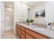 Bright bathroom featuring a double vanity with granite countertop, framed mirror, and adjacent shower/tub at 10003 Atlanta St, Parker, CO 80134