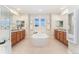 Large symmetrical bathroom featuring and vanities, a large tub, and neutral colors at 10003 Atlanta St, Parker, CO 80134
