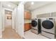 Functional laundry room with washer, dryer, built-in cabinets and shelving, plus access to the hallway at 10003 Atlanta St, Parker, CO 80134