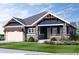 Charming single-Gathering home with a stone and blue siding, a well-manicured lawn, and an attached two-car garage at 14111 Blue Stem St, Broomfield, CO 80020