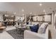 Open-concept living room featuring modern furniture and a stylish dining area with updated lighting fixtures at 14111 Blue Stem St, Broomfield, CO 80020