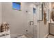 Modern shower featuring white marble style walls, a glass door, and bronze colored accents at 14111 Blue Stem St, Broomfield, CO 80020