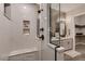 Modern shower with marble style tiling and built-in shelving, adjacent to the double vanity at 14111 Blue Stem St, Broomfield, CO 80020