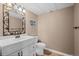 Well-lit powder room with white vanity, decorative mirror, and neutral paint at 10103 Knoll Cir, Highlands Ranch, CO 80130